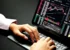 A pair of hands resting on a keyboard with an iPad showing graphs and price quotes. (Kanchanara/Unsplash)