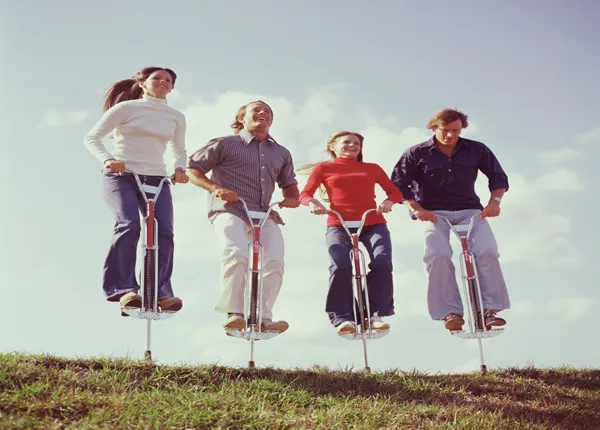 Friends jumping on pogo sticks
