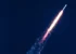 A Falcon Heavy rocket lifts off from the Kennedy Space Center with the exhaust causing a strong contrail.