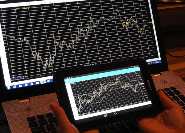 Computer screens show a security's price graph (PIX1861/Pixabay)